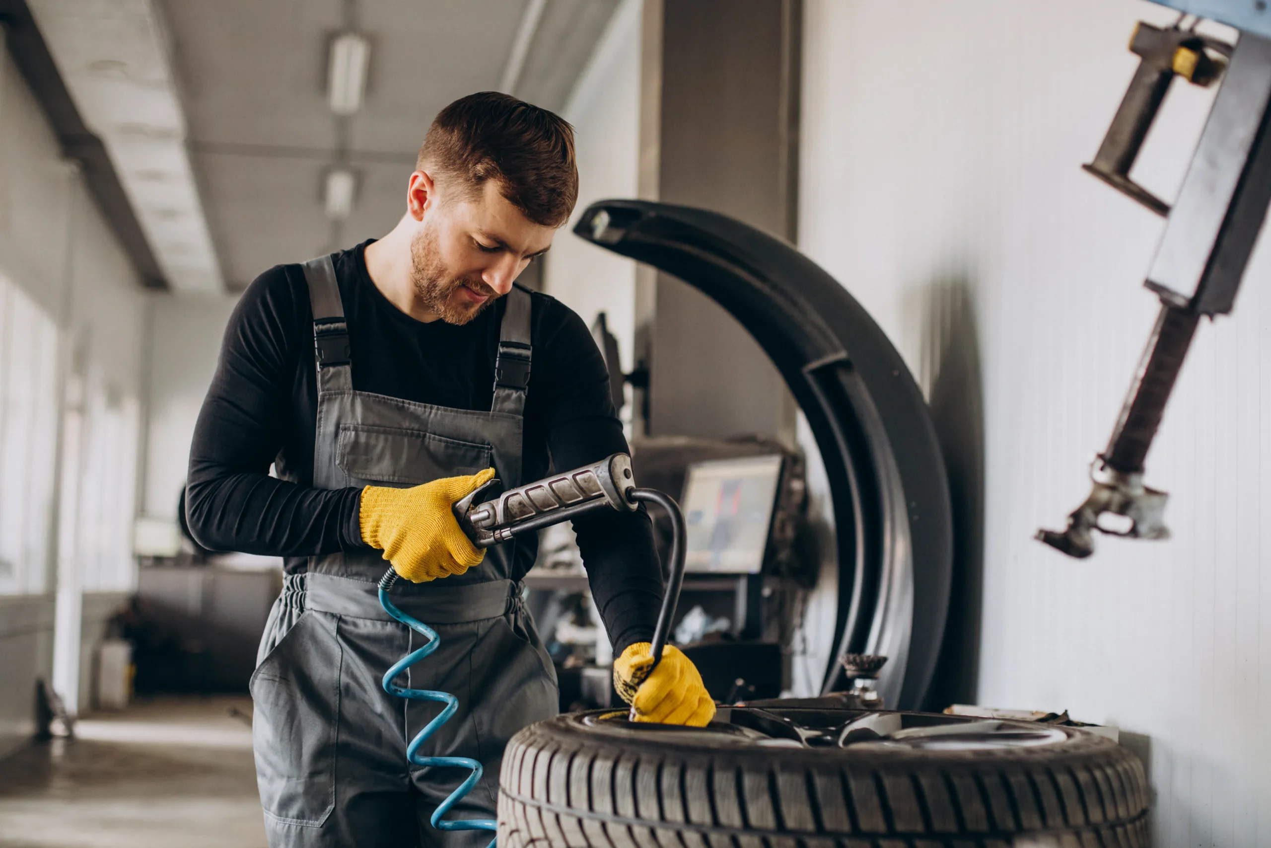 Car mechanic changing wheels in car